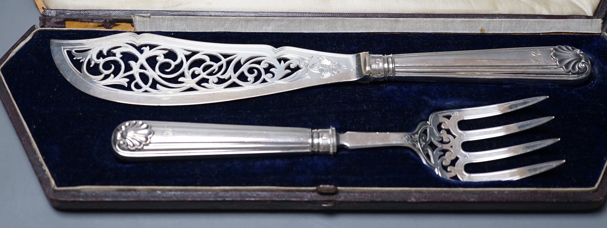 A cased pair of Victorian silver fish servers, Martin, Hall & Co, Sheffield, 1857, knife 31.2, loaded handles.
